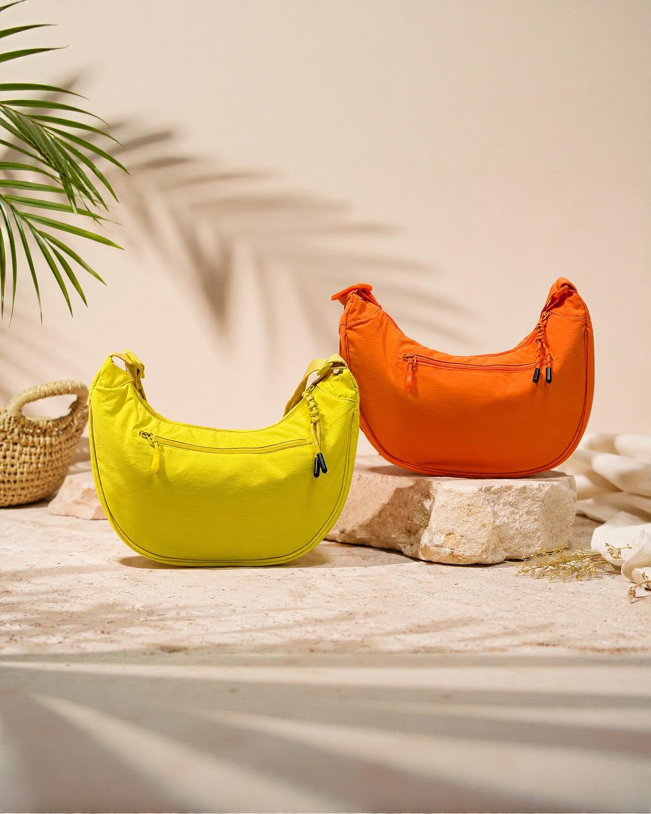 Vista frontal del bolso de media luna Almería de EUTEA en color amarillo neón y naranja neon confeccionado en nylon ligero con un bolsillo exterior de cremallera y correa deportiva regulable.
