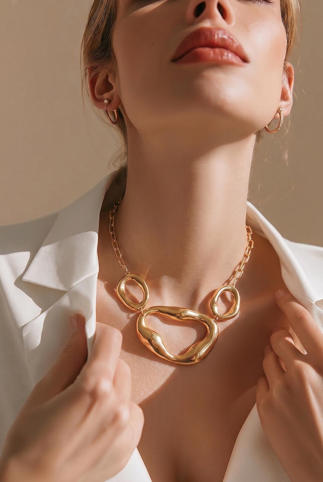 Modelo luciendo el collar de eslabones maxi orgánicos Empúries en color oro de EuTea, combinado con una americana blanca.