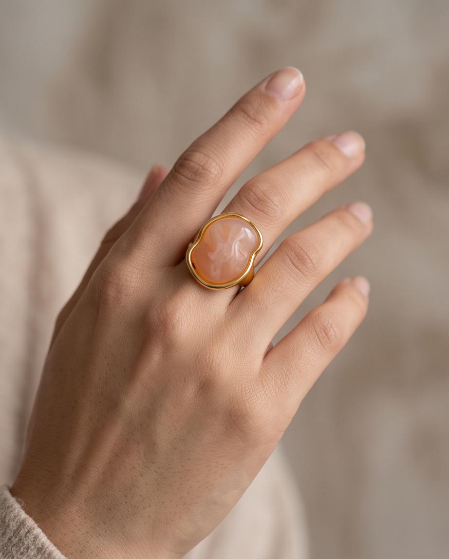 Mujer luciendo el Anillo Cadaqués dorado con piedra coral de Eutea.