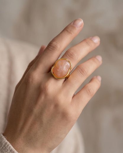 Mujer luciendo el Anillo Cadaqués dorado con piedra coral de Eutea.