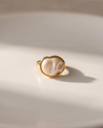 Anillo Calpe dorado con piedra efecto perla y diseño ajustable.