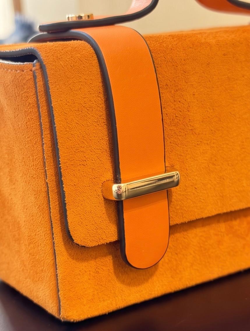 Vista del bolsos de mano de cuero rígido modelo Cunit en color naranja.