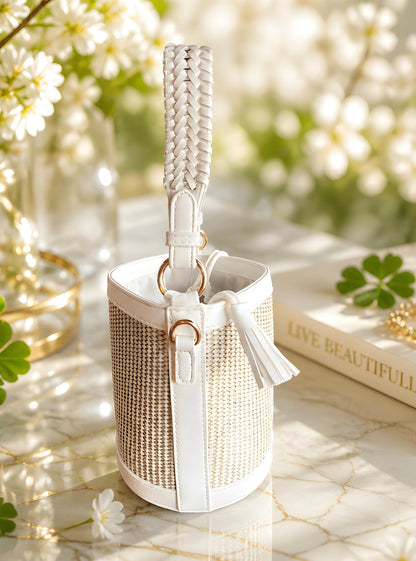 Detalle lateral de bolso capazo mini Niza de la marca EuTea, de tejido efecto rafia natural y detalles en piel sintética blanca con asa corta trenzada.
