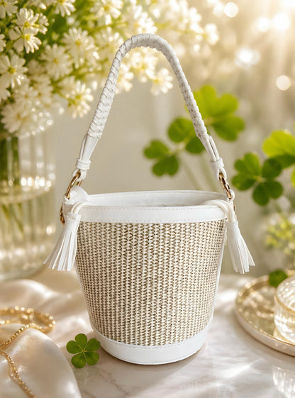 Bolso capazo mini Niza de EuTea tipo cubo, color blanco y natural, con cierre de cordón ajustable, borlas decorativas y asa corta de mano trenzada.