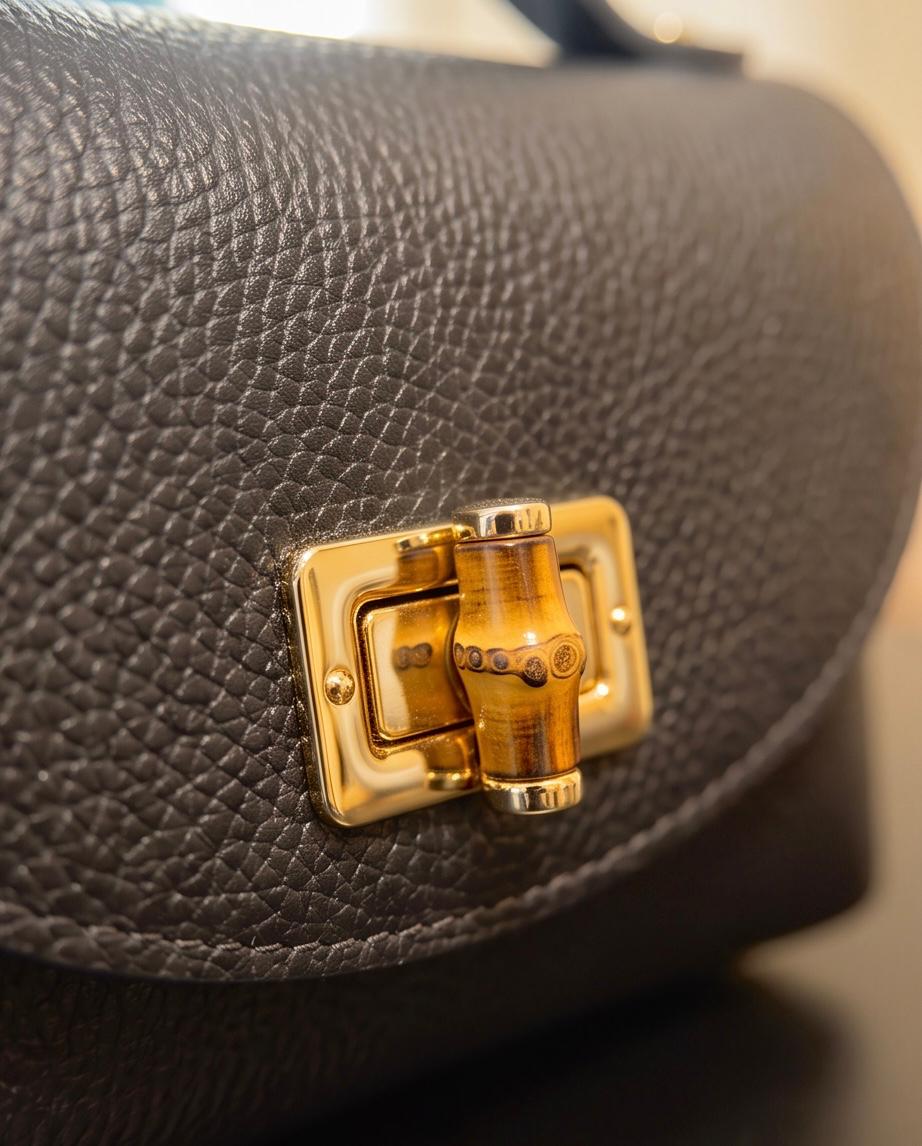 Detalle del cierre dorado efecto bambú del bolso Firenze negro