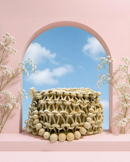 Vista detallada del bolso Calella de EUTEA, mostrando el intrincado tejido de nudos de macramé, el cierre superior de cremallera y el forro interior estructurado en tono beige.