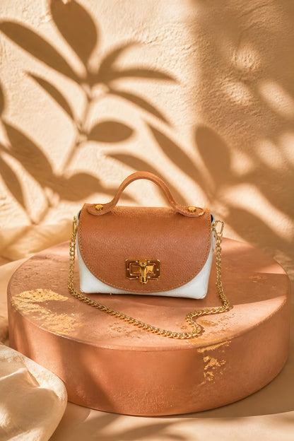 Bolso mini de piel auténtica color camel y crema con cadena dorada y asa de mano.