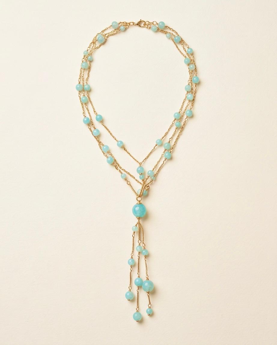Collar Cascada completo con múltiples cadenas doradas y cuentas azul turquesa.