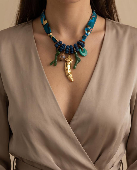 Mujer luciendo el Collar Larios con un vestido beige en un elegante look de verano.