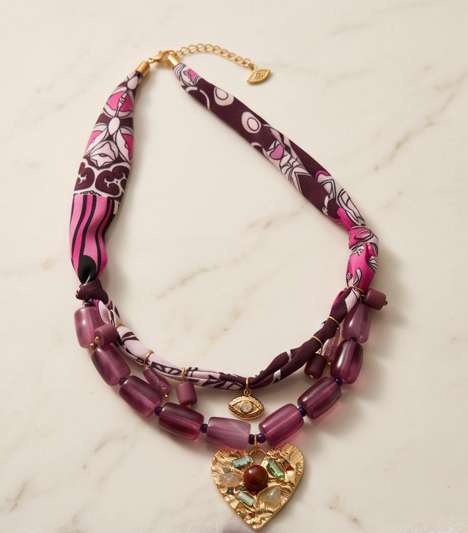 Collar Pals colocado sobre superficie de mármol con detalles decorativos que resaltan su diseño artesanal.