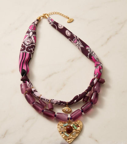 Collar Pals colocado sobre superficie de mármol con detalles decorativos que resaltan su diseño artesanal.