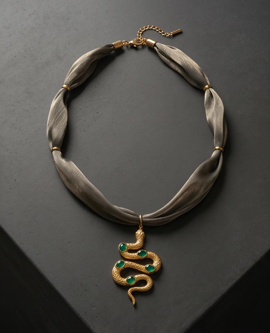 Collar de tejido gris con serpiente de acero dorada y detalles verde esmeralda.