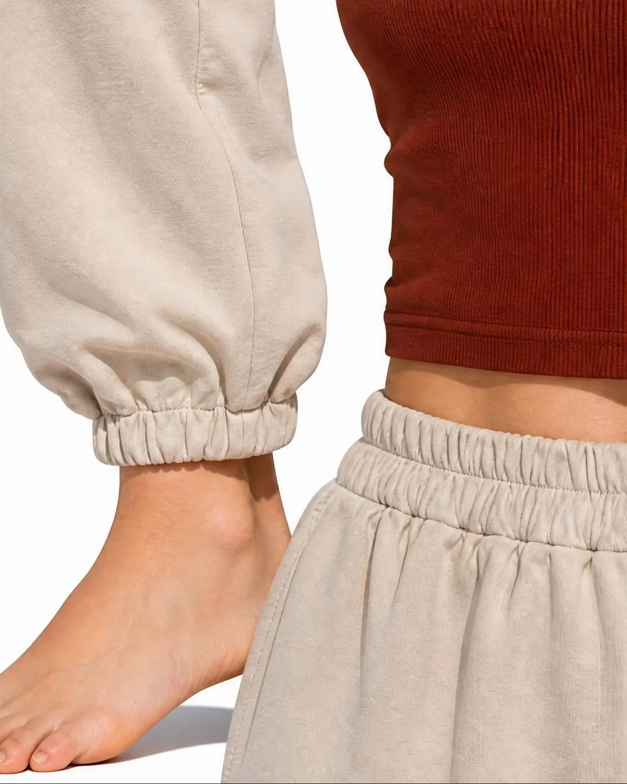 Primer plano de los detalles elásticos del pantalón Alcazaba color beige de EUTEA, destacando el fruncido de la cintura alta y el acabado del puño elástico del tobillo