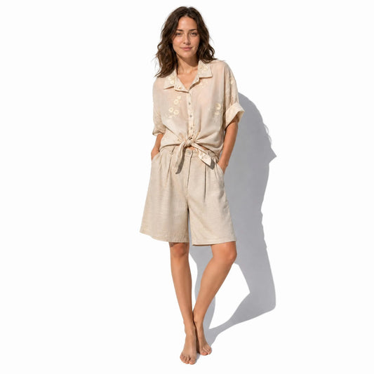 Blusa translúcida beige Vilassar con bordados florales y nudo en la cintura de la marca EUTEA.