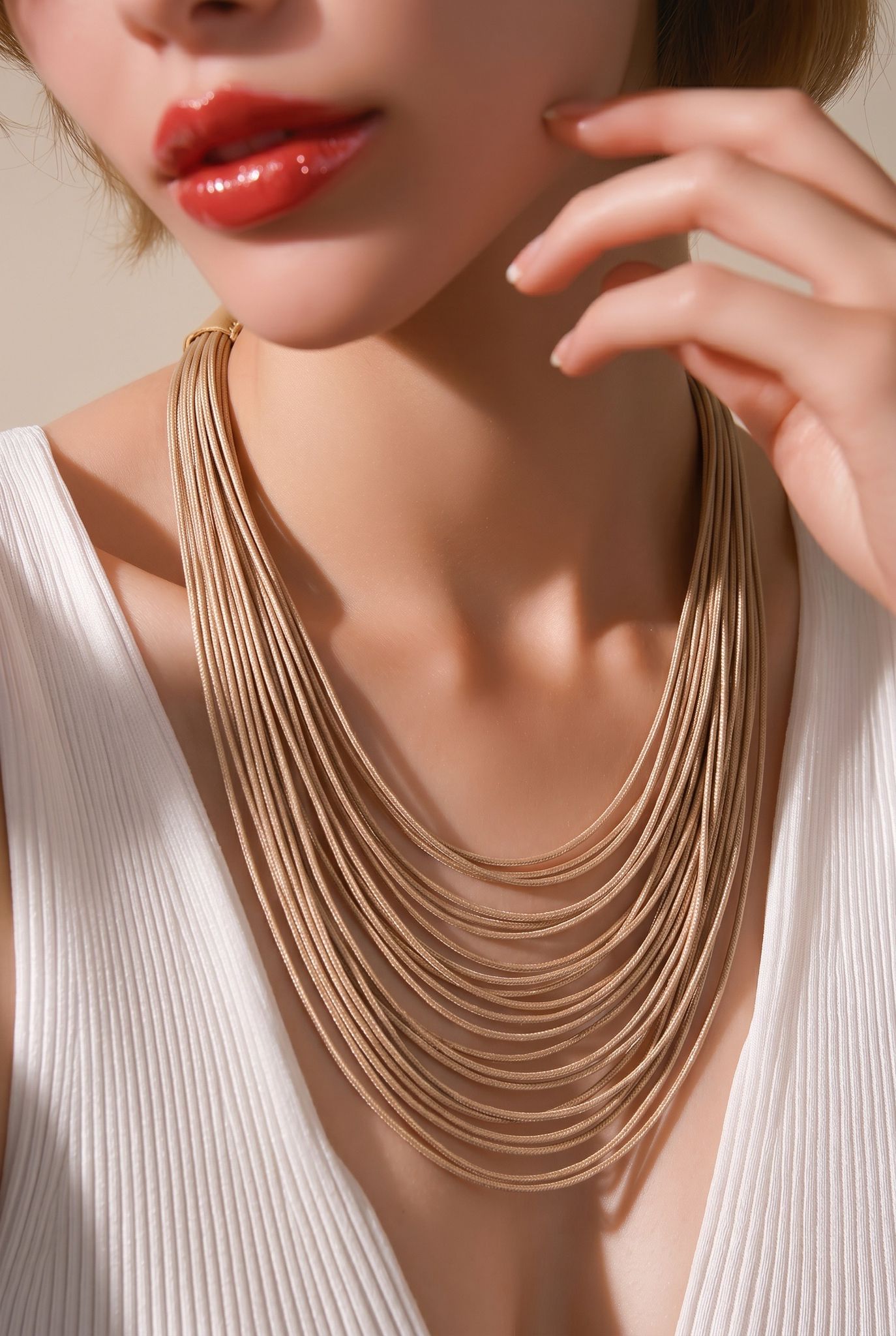 Modelo luciendo el collar multi-hilera de algodón Pals en tono oro champán de EuTea, combinado con un top blanco.