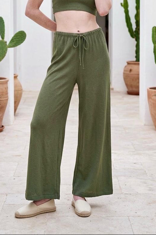 Modelo luciendo el total look de top corto y pantalón wide leg fluido de viscosa en color verde caqui.