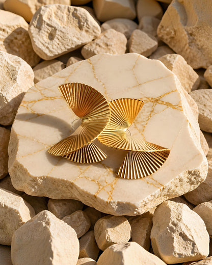 Pendientes escultóricos Cerdanya de la marca EuTea en color oro, de acero inoxidable con diseño plisado en espiral sobre una piedra.