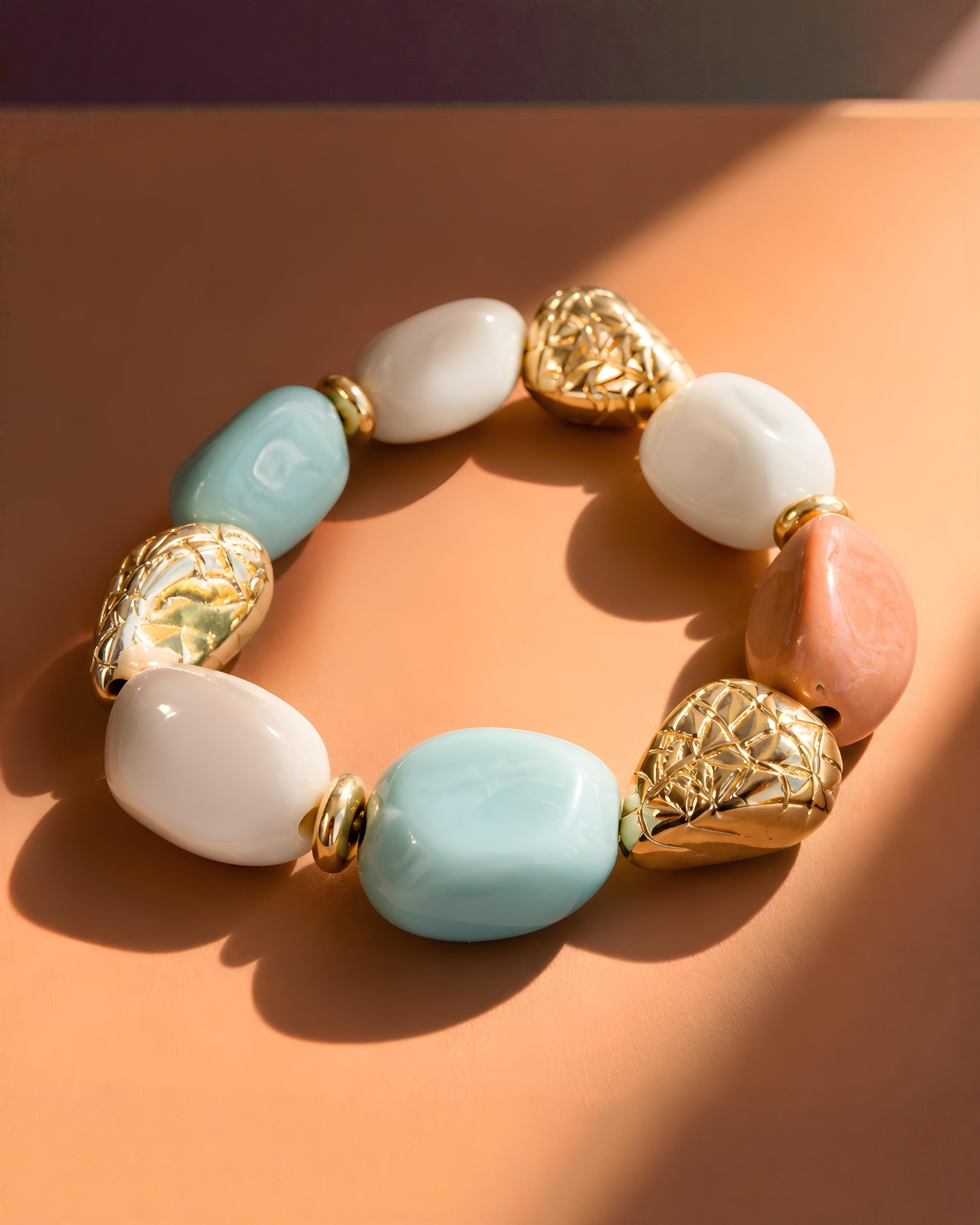 Pulsera de resina adaptable Puigcerda versión multicolor de EuTea, con piezas efecto piedra en tonos azul claro, coral, blanco y detalles oro.
