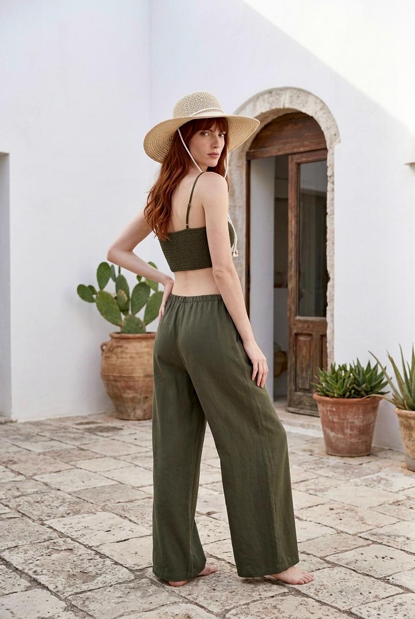 Modelo posando con conjunto de top bralette corto de viscosa en color verde caqui Amara y pantalón fluido a juego.