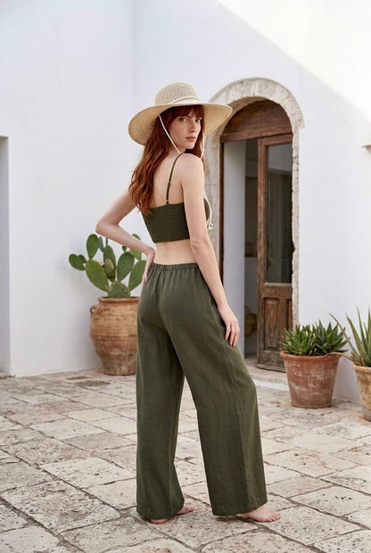 Modelo posando con conjunto de top bralette corto de viscosa en color verde caqui Amara y pantalón fluido a juego.