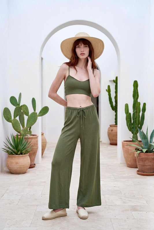 Modelo posando con conjunto de top bralette corto de viscosa en color verde caqui Amara y pantalón fluido a juego.