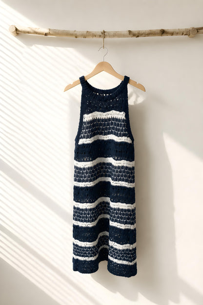 Vestido corto de crochet a rayas color blanco y azul colgado en percha de madera - Eutea Beachwear